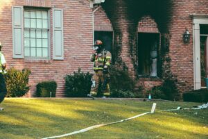 Fire fighter walking out of a house